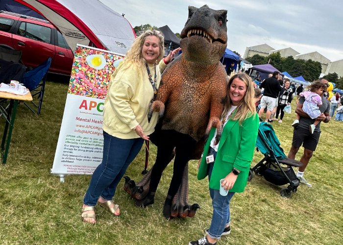 The APCAM team meeting a dinosaur at a community fun day