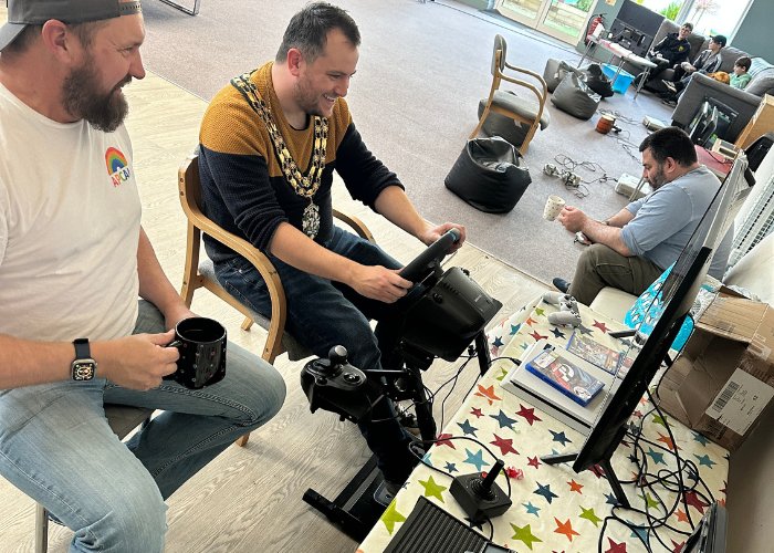 The Mayor trying out the racing simulator at a WeGame session